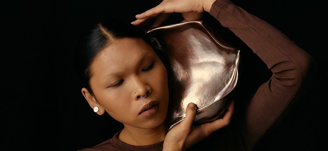 Une personne écoute un gros coquillage